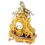 A late 19thC gilt metal mantel clock, the 8cm Dia. enamel dial fitted in an elaborate rococo case,