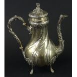 A Continental silver coloured metal coffee pot, of rococco form, cast with scrolls, flower heads