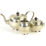 A George V silver three piece tea set, a bullet shaped teapot, with engraved band, ebonised knop and