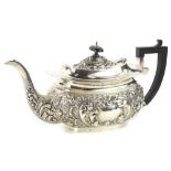 A late Victorian silver teapot, of rectangular form, embossed with scrolls etc., the lid with an
