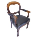 A Victorian style mahogany balloon back library chair, with an oval back, black leather padded