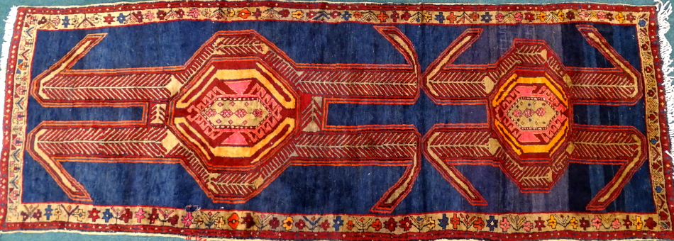 An Azari runner, with a long pole type medallion in red, orange, pink etc., on a navy ground with