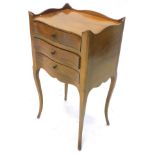 A continental birch bedside cabinet, with a raised top, three drawers on cabriole legs, possibly