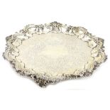 An Edwardian silver salver, the piecrust border, cast with shells, scrolls etc., engraved