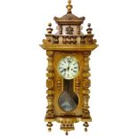 A Vienna type walnut wall clock, with a shaped crest, a printed dial with Roman numerals etc., 126cm