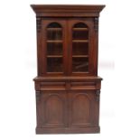 A Victorian mahogany cabinet bookcase, with ogee moulded cornice, over two arched glazed doors,