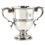 A Victorian silver two handled cup, with leaf cast thumb pieces, a moulded band and a tapering foot,