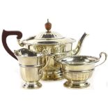 A George V silver three piece tea set, with a part faceted body, gadrooned border, the teapot with