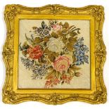 A 19thC wool work picture, still life with flowers etc., on linen backing with contemporary gilt