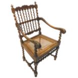 A Continental open armchair, with spindle turned supports, the shaped arms carved with leaves and
