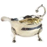 A 19thC silver sauce boat, with three shaped feet, double scroll handle, crested, London assay, date