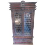 A Continental carved oak display cabinet, the top with a spindle turned, carved and moulded triple