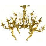 A set of four large gilt metal wall lights, each with rococo scroll casting, 56cm H and a similar