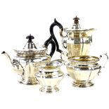 A George V silver four piece tea set, the teapot and hot water jug with ebonised knop and handle,