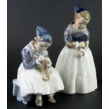Two similar Royal Copenhagen porcelain figurines, each depicting a young girl wearing Danish