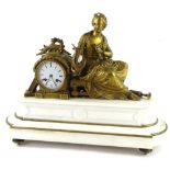 A 19thC French gilt brass figural mantel clock, the enamel dial seated between two books and a