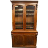 A Victorian mahogany cabinet bookcase, with ogee moulded cornice, carved scroll supports and two