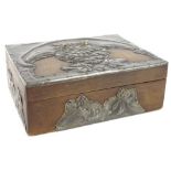 An early 20thC wooden cigarette box, mounted with arts and crafts hammered pewter design of an