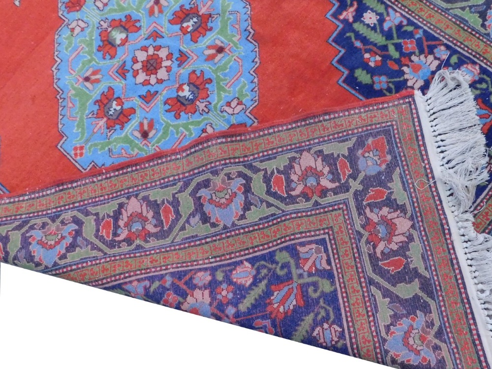 A Persian type rug, with a central blue medallion, on a red ground, with navy spandrels, one wide - Image 2 of 3