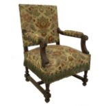 A 19thC French walnut open armchair, with floral tapestry studded upholstery, acanthus carved scroll