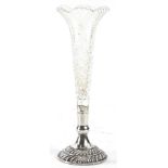 A late Victorian cut glass trumpet shaped bud vase, the silver base with gadrooned bands etc.,