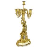 A late 19thC French gilt metal seven branch candelabra, with putti support, the base inset with a