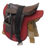 A brown leather horse's saddle, with metal stirrups, canvas under saddle etc.