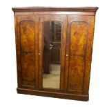 A Victorian figured walnut triple wardrobe compactum, with moulded cornice, central mirror door,