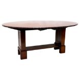 A mahogany oval dining table, with a carved moulded edge, on square section end supports and block