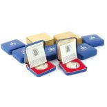 Nine Queen Elizabeth II silver Jubilee Royal Mint coins, each in a blue case with packaging.