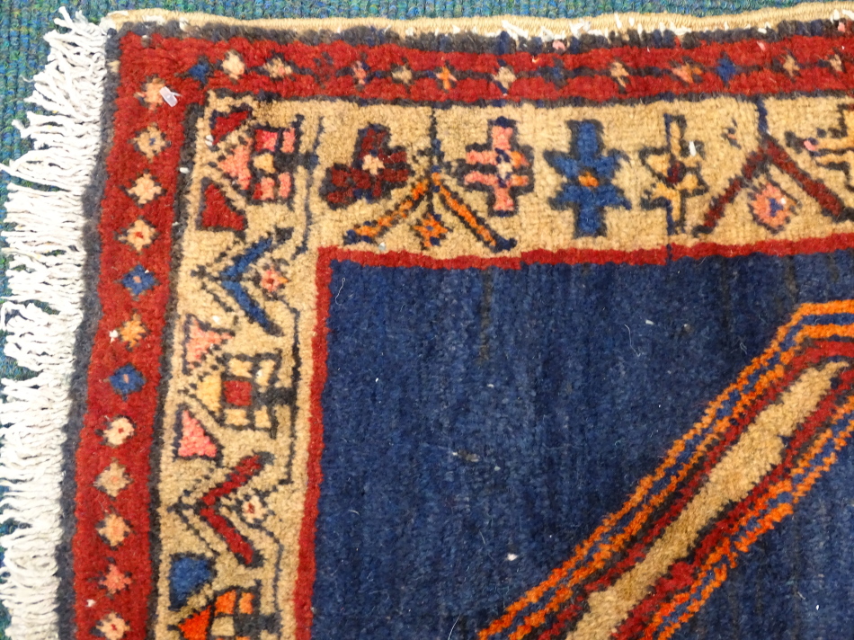 An Azari runner, with a long pole type medallion in red, orange, pink etc., on a navy ground with - Image 2 of 3