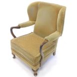 A walnut wingback armchair, with upholstered back, loose cushion etc., on cabriole legs.The