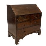 A George II mahogany bureau, with fall flap resting on lopers, revealing a fitted interior of