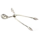 A pair of Georg Jensen white metal sugar tongs, each with a pierced handle, decorated with flower