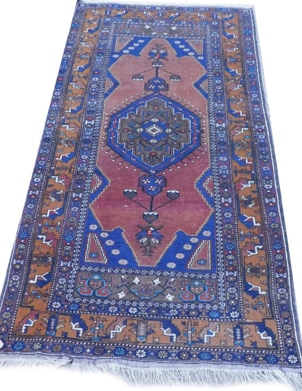 A Persian type rug, with a central pole medallion, on a deep rust ground with blue spandrels, one