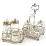 A George V silver four bottle cruet, with pierced sides and handle, some glass jars with silver