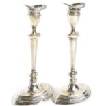 A pair of Edwardian silver navette shaped candlesticks, each with a separate sconce and a moulded