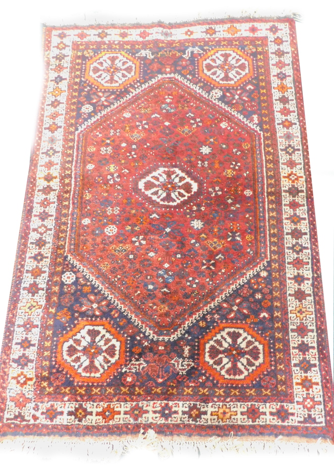 Two similar Turkish type small rugs or mats, each on an orange ground, 86cm x 65cm and 87cm x 63cm.