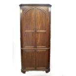 A George III mahogany standing corner cupboard, with moulded cornice and two double panelled arch