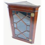 An early 19thC mahogany and boxwood strung corner cabinet, with a moulded cornice, above a single