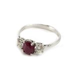 A ruby and diamond three stone ring, with pigeon cut ruby approx 1.78cts, flanked by two round
