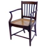An early 19thC mahogany open armchair, with a rail back and a cane seat on square tapering legs.