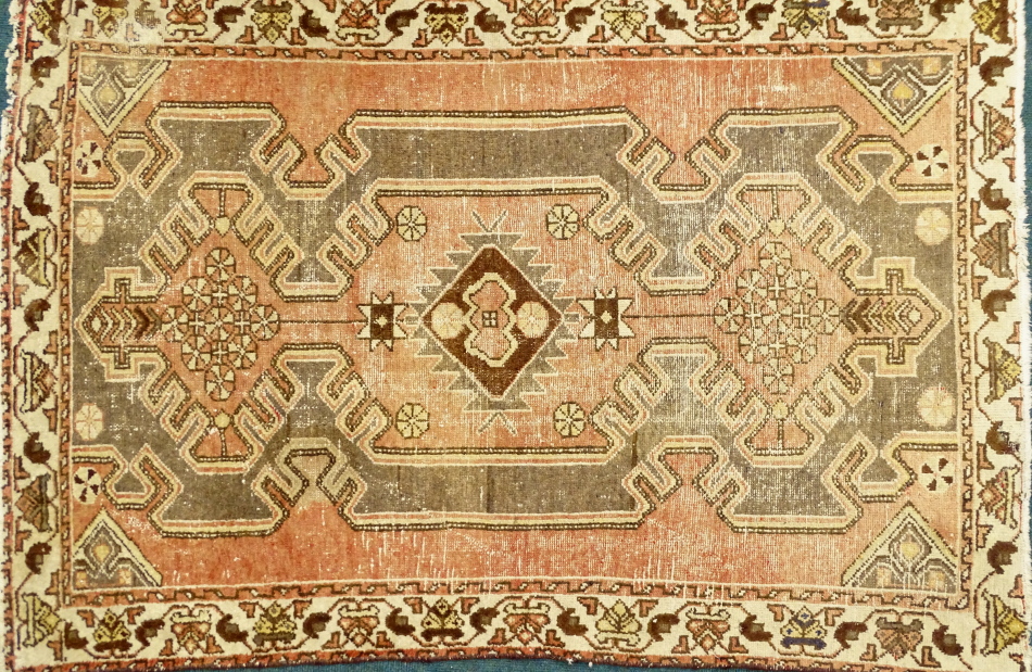 An Azari rug, with a central medallion on a red ground with one wide border, (AF), 190cm x 125cm.