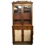 A William IV walnut cabinet bookcase, with scroll carved and moulded frieze with roundels, over