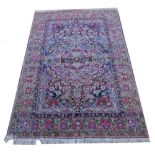 A Persian silk type rug, with an all over multicolour design of flowers, birds etc., surrounding a