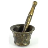 A 17thC bronze mortar, with indistinct cast decoration, 7cm H, 10cm dia. and an associated pestle,