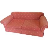 A two seat sofa, upholstered in coral fabric.The upholstery in this lot does not comply with the
