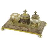 A Victorian brass and copper inkstand, with two wells, a central jar and cover, decorated with