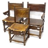 A pair of late 19th/early 20thC oak armchairs, each with a brown leather back and seat, on bobbin