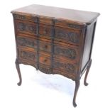 A continental stained beech serpentine commode chest, the break front top with a moulded edge, above